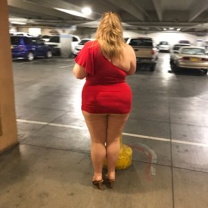 married redhead in red minidress pantyhose and heels at a casino parking lot on a date with my bull